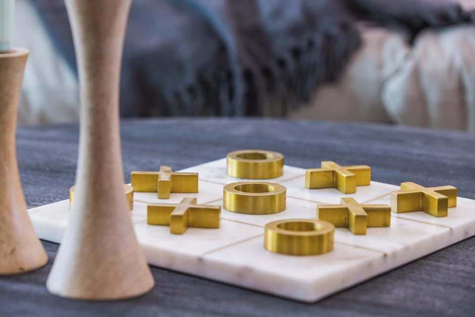 Play a round of tic-tac-toe on this luxe marble and brass coffee table set