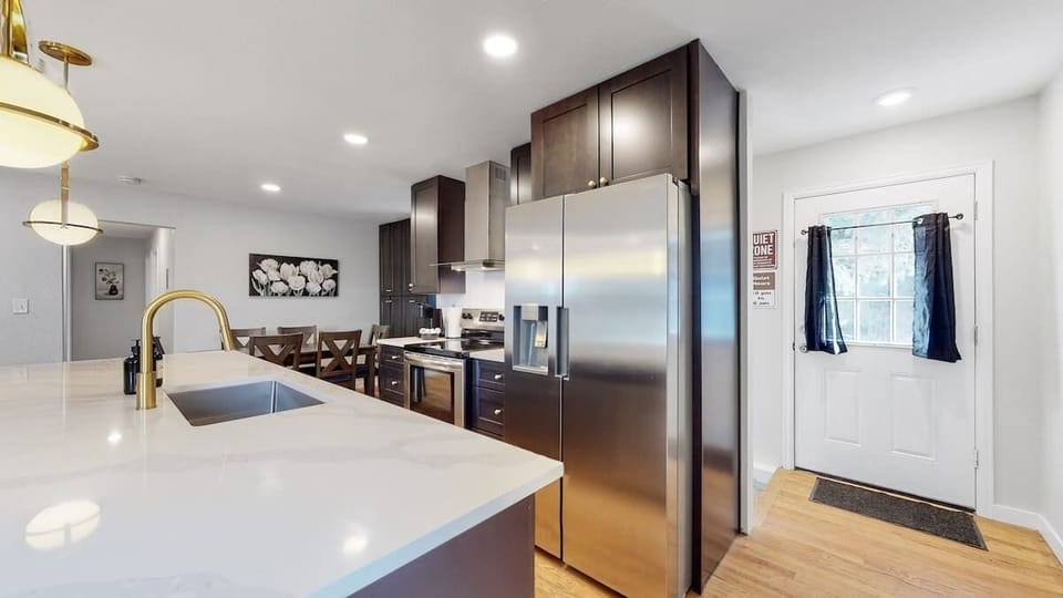 A beautifully designed kitchen with sleek dark cabinetry, stainless steel appliances, and a spacious island, offering both functionality and style.