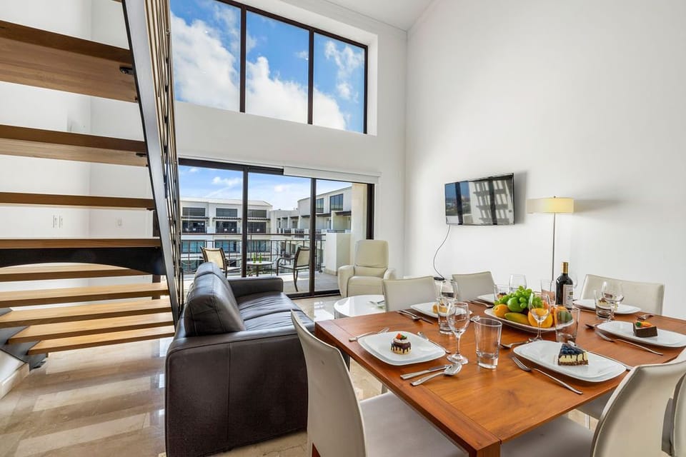 An open space concept living room and dining room with high ceilings.