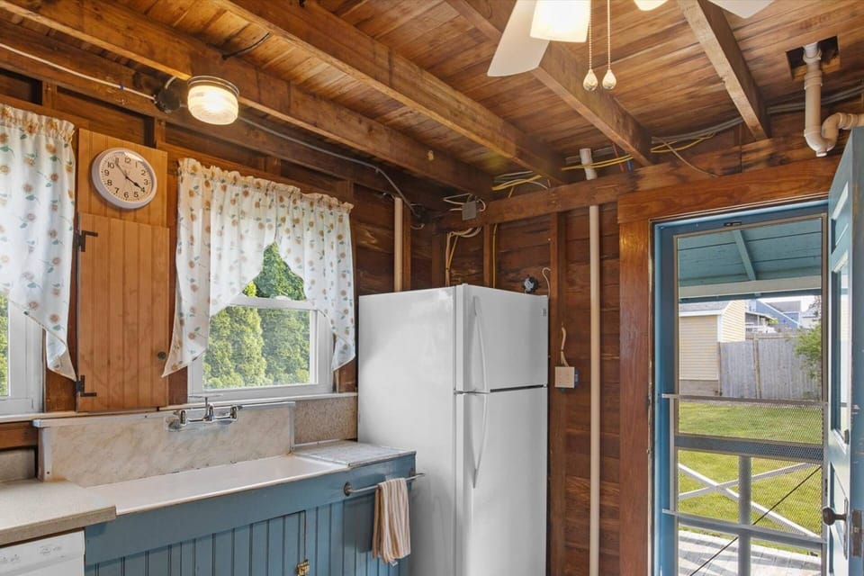 Refrigerator and freezer, dishwasher, and view of the back porch and partially fenced-in yard