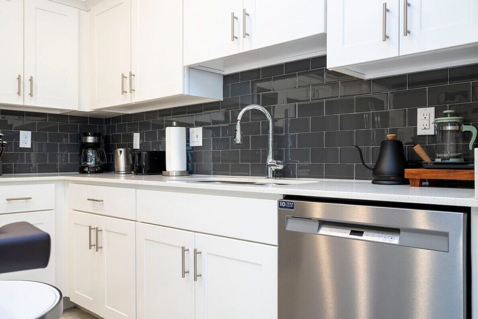 The fully equipped kitchen features modern appliances, sleek cabinetry, and all essential cookware and utensils, making it perfect for preparing meals with ease.