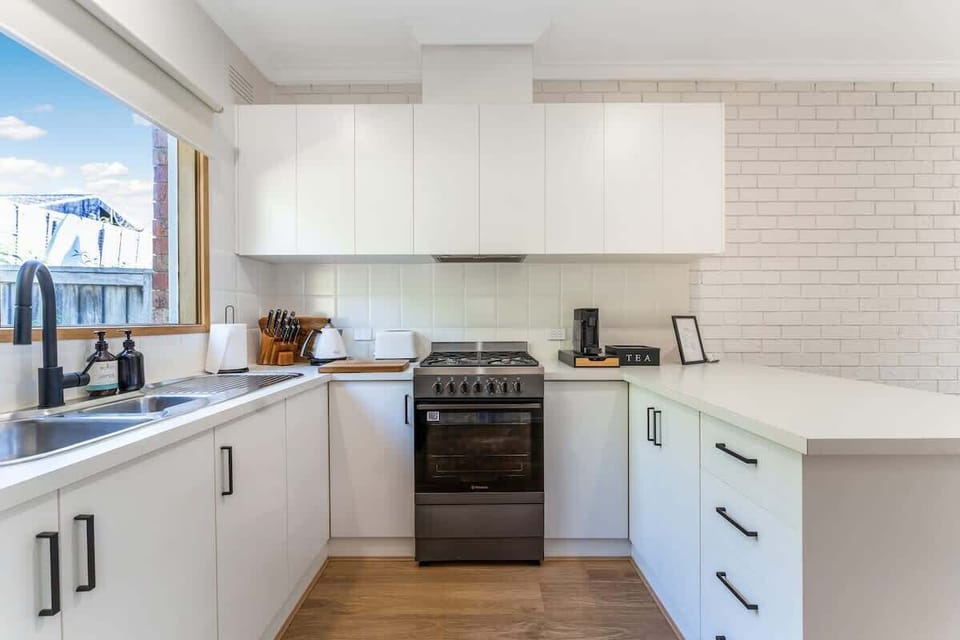 Modern kitchen with breakfast bar and coffee pod machine. 