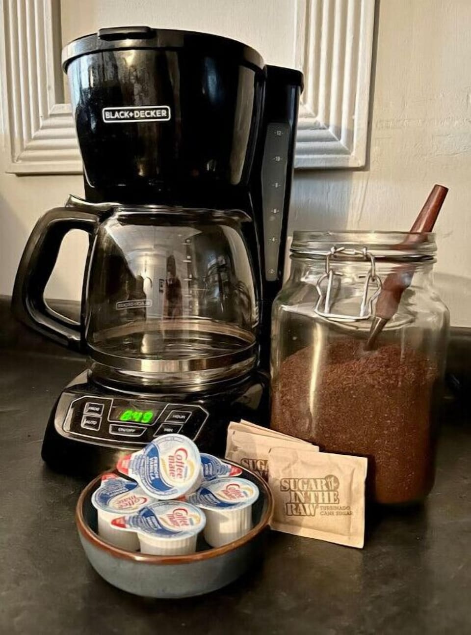 Ground coffee, filters, sugar, and creamer provided.