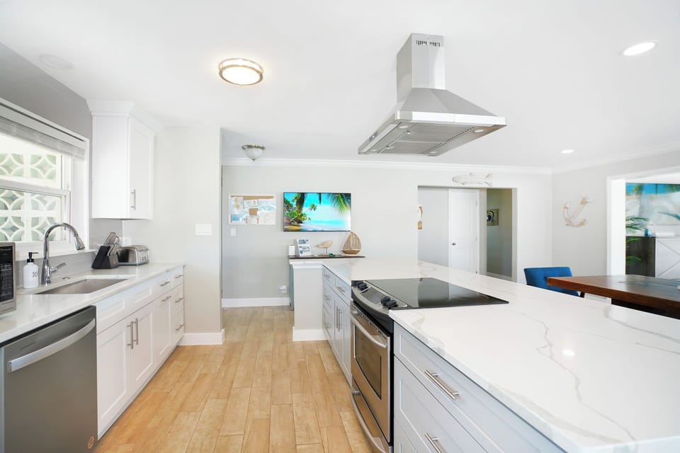 The smart TV in the kitchen allows the cook to enjoy the game or movie also.