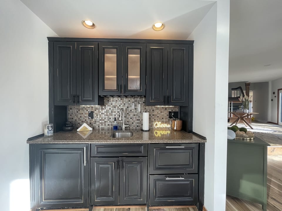 wet bar with a large wine/drink refrigerator and two drawer refrigerators. 