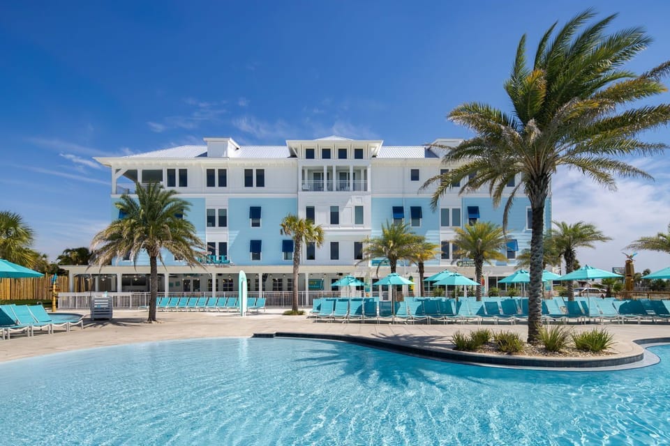 Dive into relaxation by the shimmering pool surrounded by palm trees and sun-soaked lounge chairs.
