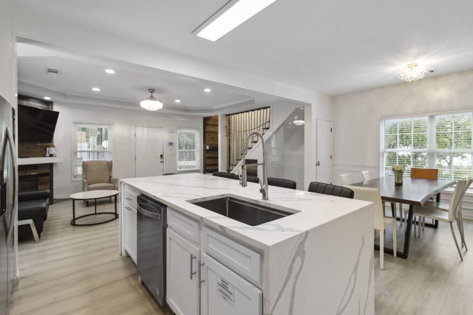Step into a kitchen where modern design meets everyday functionality—a sleek culinary haven that’s as stylish as it is practical. Anchored by a chic bar counter with high chairs, this space invites casual conversations over coffee or cocktails. The minima