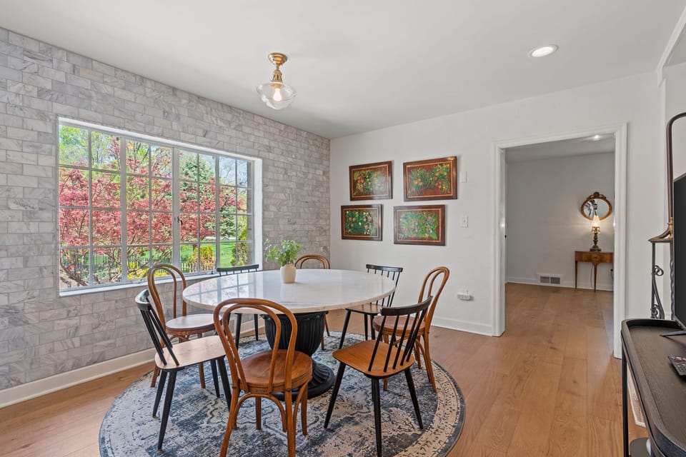 Light-filled dining area with large windows, comfortable seating, and a Smart TV nearby, creating a welcoming spot for breakfast, dinner, or planning your Kansas City adventures.