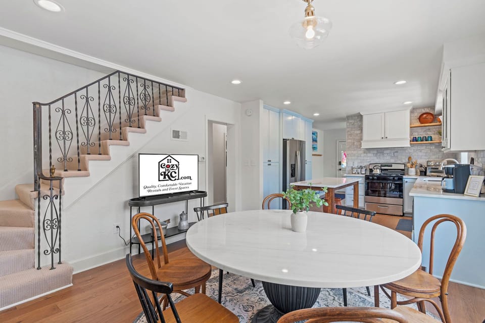 Bright dining space with modern lighting, easy kitchen access, and a Smart TV just steps away—perfect for shared meals, game nights, or relaxing together during your stay.