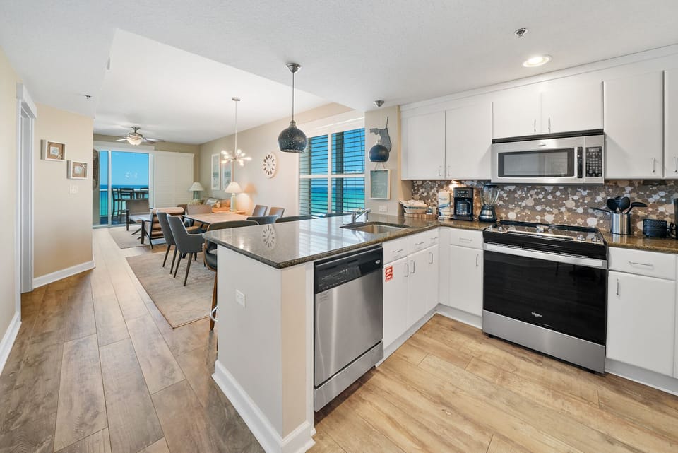 Your spacious modern kitchen flows seamlessly into the dining area, featuring sleek white cabinets, granite countertops, and all the appliances you need for memorable meals.