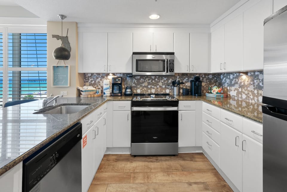 Your fully-equipped modern kitchen awaits, featuring granite counters, stainless appliances, and a gorgeous mosaic backsplash for memorable meal prep.