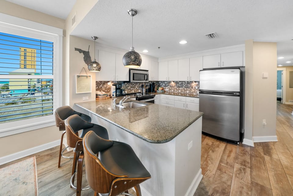 Your sleek modern kitchen features granite countertops, stainless steel appliances, and stylish pendant lighting perfect for cooking memorable meals.