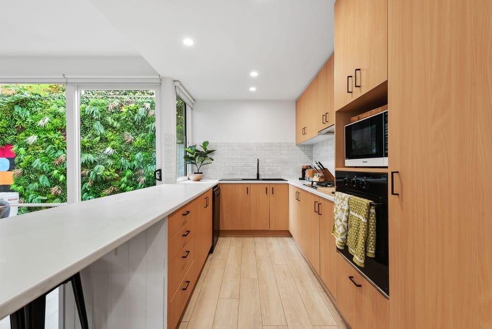 Kitchen with a stove, microwave, sink and cabinets 