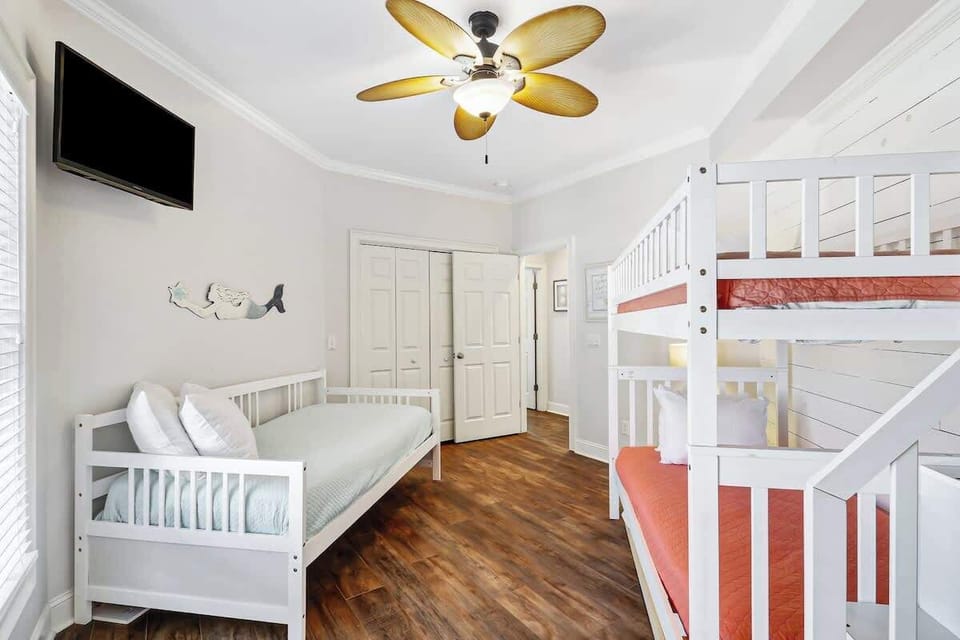 Your kids will love this bright bedroom with bunk beds and coastal charm, complete with ceiling fan for comfort.