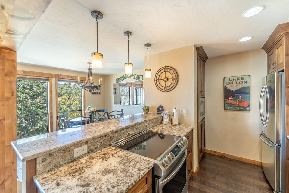 Your gourmet kitchen features granite counters, stainless appliances, and forest views through expansive windows—perfect for cooking memorable meals.
