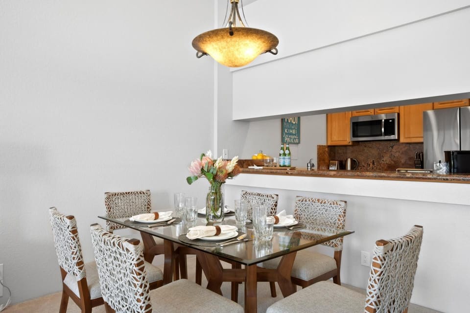 Step into a dining dream where safari-chic chairs meet golden-glow chandeliers and tropical blooms whisper aloha   