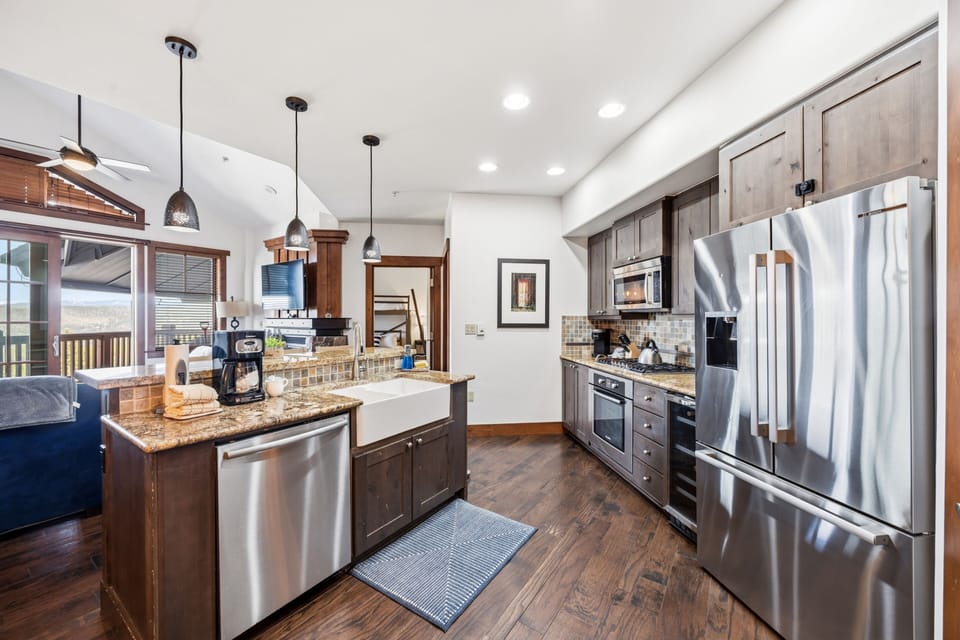 Galley kitchen — apron sink, marble counters, peninsula bar.
