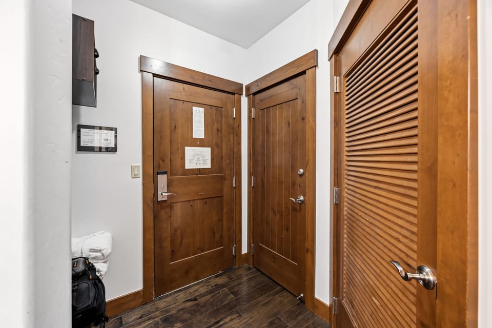 Foyer entry — keypad door, knotty pine, hardwood floor.