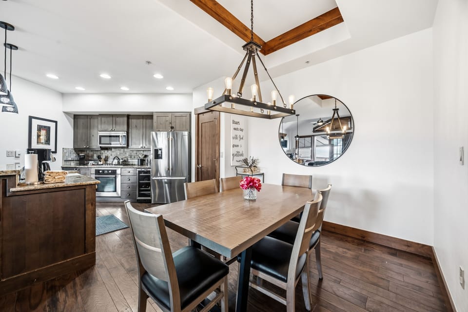 Dining and kitchen flow under the candelabra chandelier.