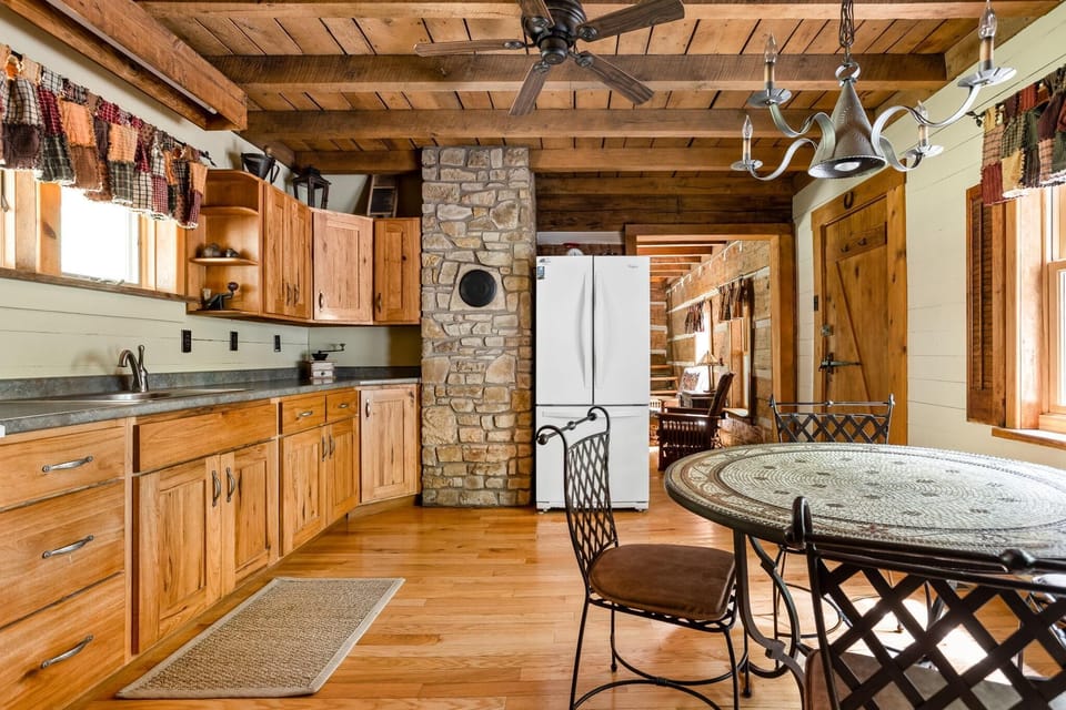 Sunlight filters through windows onto the mosaic-tiled dining table and wrought-iron chairs in the kitchen.