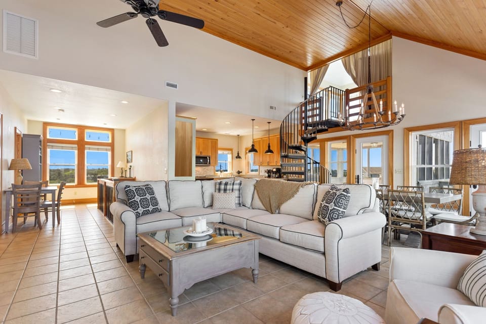 The top-level living area features soaring ceilings, abundant natural light, and stunning sound views.
