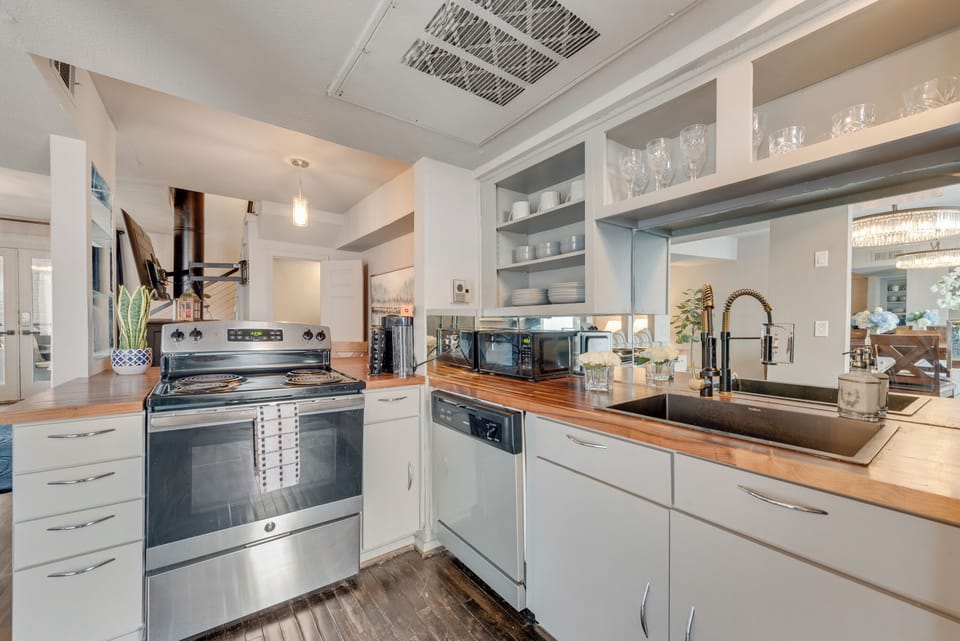 The modern kitchen is fully equipped with sleek appliances, perfect for preparing meals. Stylish bar seating offers a casual spot for dining or chatting with the chef.
