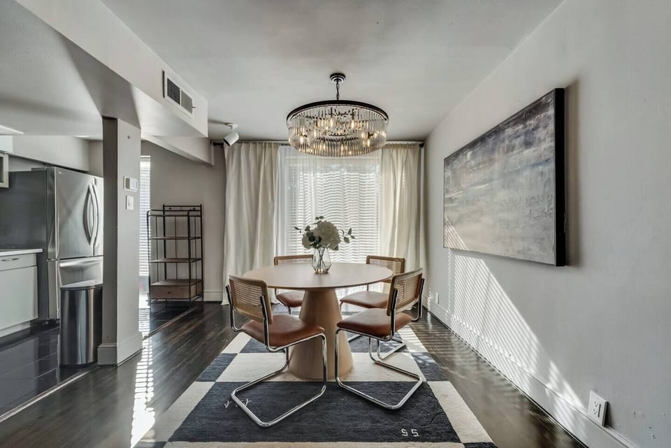 Open dining area with seating for four, featuring a beautiful chandelier..
