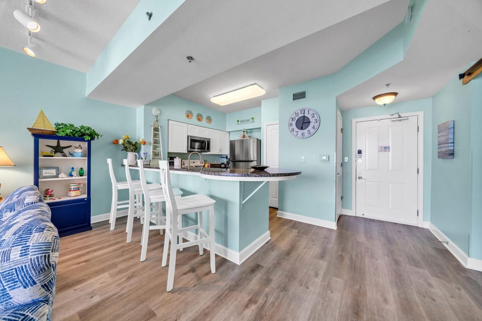 Granite topped Breakfast bar with four comfortable stools overlooks kitchen