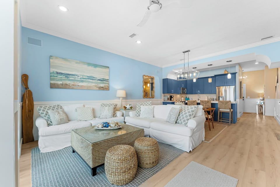 Beachfront living room with comfortable seating, Smart TV, and direct balcony access overlooking the Gulf