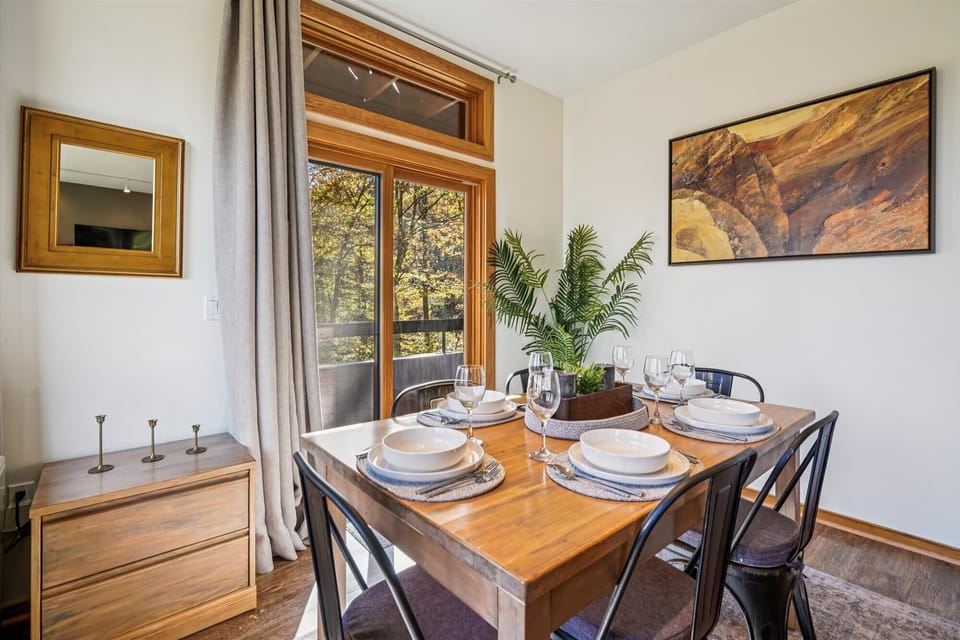 Bright dining area for four with large windows and sliding doors leading to the private balcony.