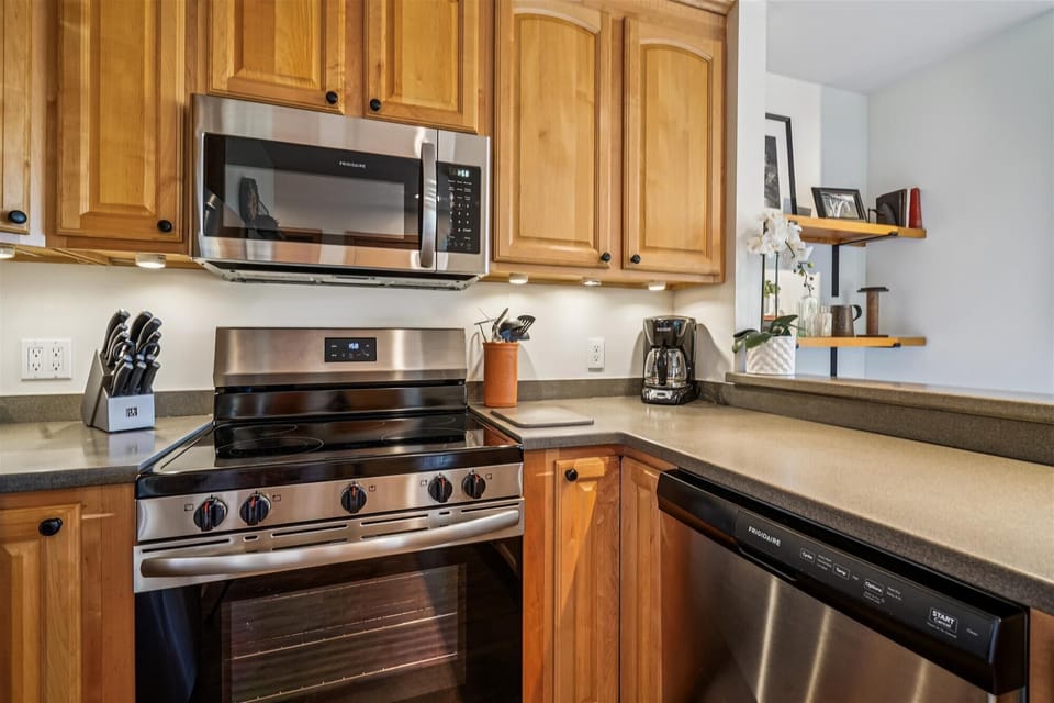 Clean, functional kitchen layout with coffee maker, cookware, and everything needed for dining in.
