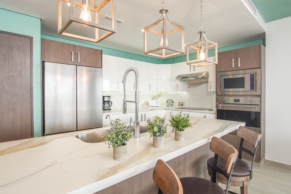 The kitchen has a long counter with seatinng