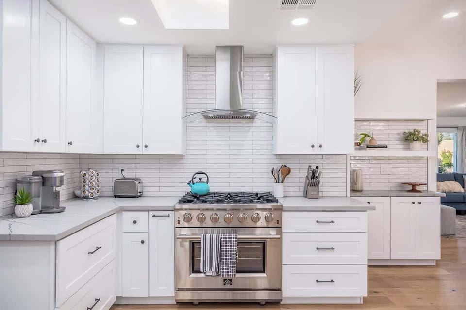 Prepare your favorite meals in this bright, spotless kitchen with sleek white cabinetry, professional-grade stainless appliances, and a crisp subway-tile backsplash. Plenty of counter space and storage make cooking feel effortless.