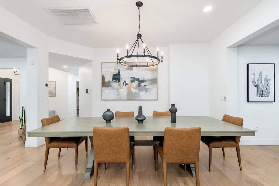Picture yourself gathered around this elegant dining table, enjoying meals together under warm chandelier light. The open layout and contemporary design create a welcoming space for your vacation dining.