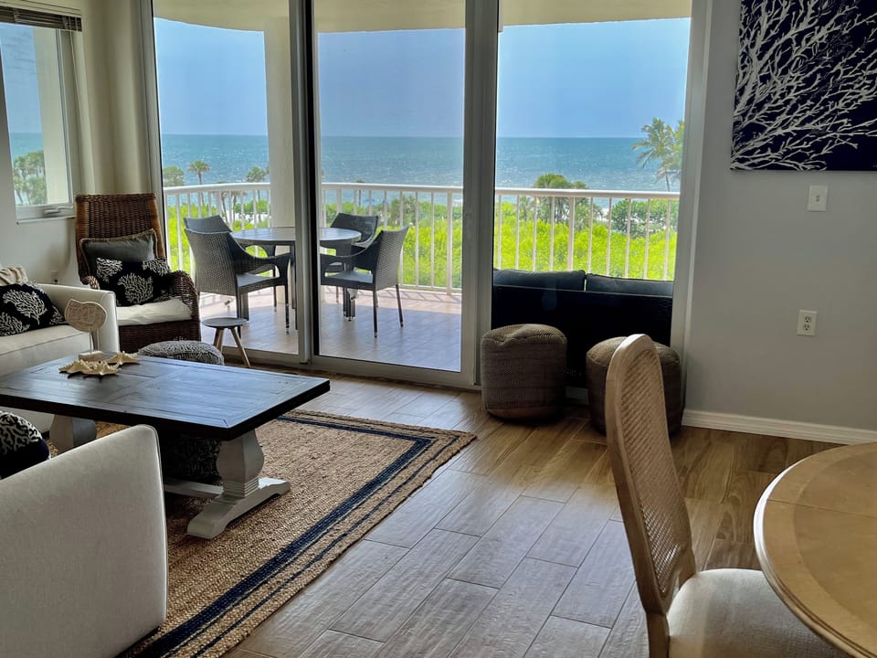 Wide dining and living room with water views from every angle