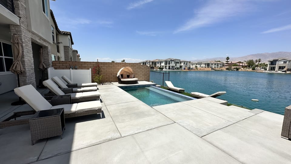 Pool/spa with lake views, lounge chairs, couches, fire pit