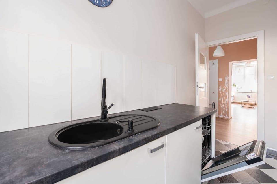 A close-up of the iconic checkerboard flooring in the kitchen, paired with white cabinetry and black counters.