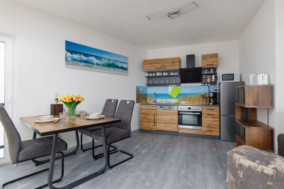 A view of the open-plan kitchen and living room, showcasing the space's contemporary furniture and colorful accents.