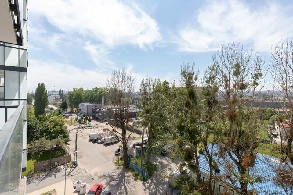 A view from above showcasing nearby construction, trees, and parked vehicles.