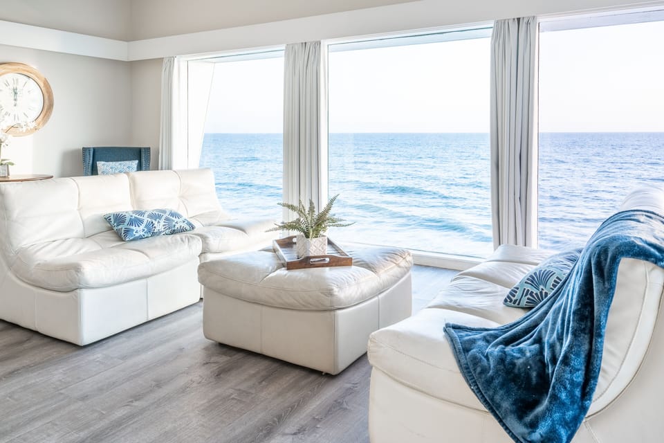 Coastal living room with white leather sofas and sweeping ocean