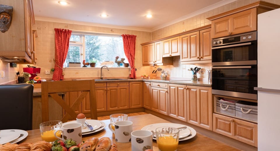 Four Pines Lodge dining table set for breakfast with kitchen