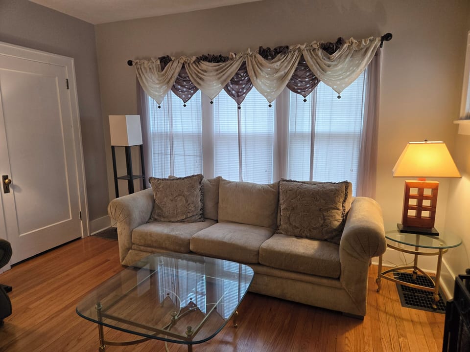 Living Room with front entry door shown. Large sofa provide extra sleeping area 
