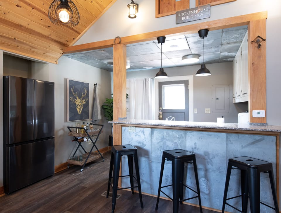 Warm up your morning coffee at this stylish breakfast bar, where rustic wood meets modern touches in your mountain retreat.