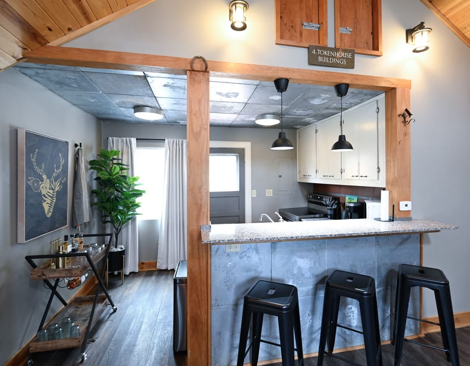 Gather around your open kitchen island where industrial-chic meets rustic charm, perfect for morning coffee or evening conversations.