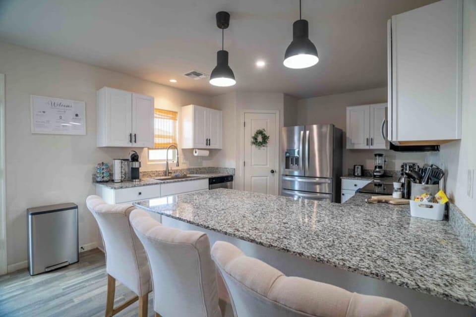 Kitchen bar area with bar stool seating and stainless appliances.