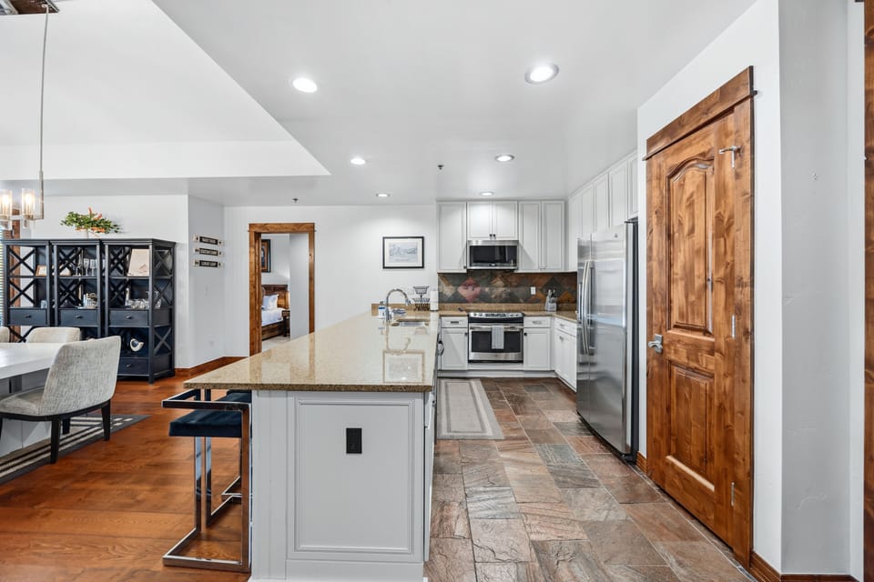 Full chef's kitchen with granite island, slate floor, stainless suite
