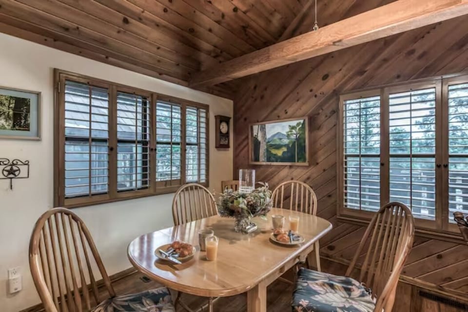 The dining area has a table with four chairs, plus a bar area with barstools.
