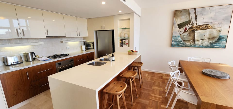 Open plan kitchen & dining with breakfast bench and stools. Comfortably seats 6.