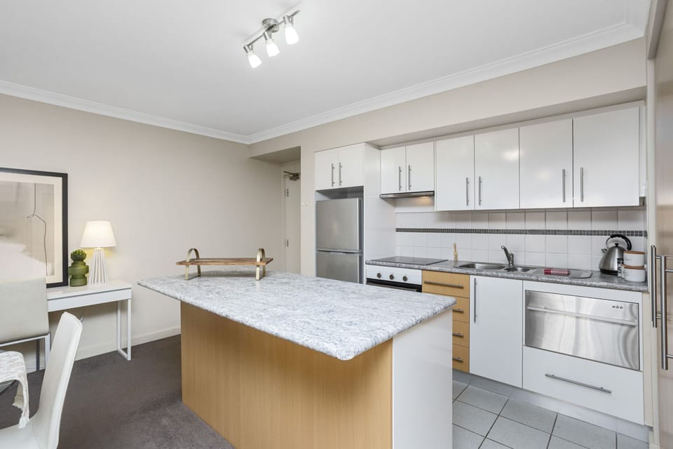 Imagine cooking a delicious meal in this modern kitchen, complete with a spacious island and plenty of counter space.