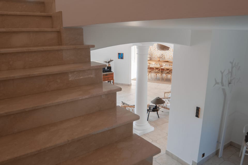 The stairs up to the second floor. The living room in the background.